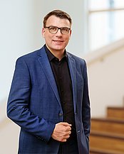 Portrait of a man in front of a staircase