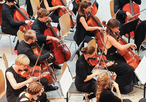 Nahaufnahme von Musiker:innen mit Streichinstrumenten.