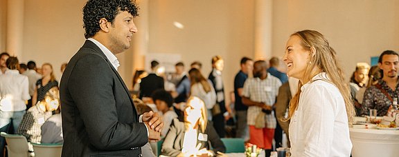 Foto von zwei Personen in einer Gesprächssituation.