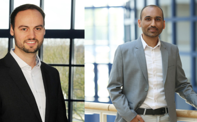 Two young men stand in the building of Witten/Herdecke University