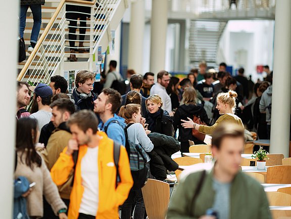 Studierende laufen durch die Campushalle.