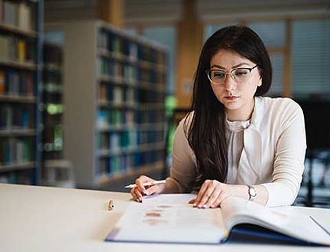 Eine Studentin im Fach Management (B. Sc.) lernt in der Bibliothek