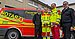 Four people are standing in front of an ambulance. 