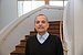 Prof. Dr. Dr. Vladimir Todorov stands in front of a staircase at UW/H and looks into the camera.