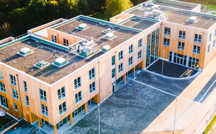 Aerial view of the UW/H campus. The focus is on the timber construction and the campus forecourt.