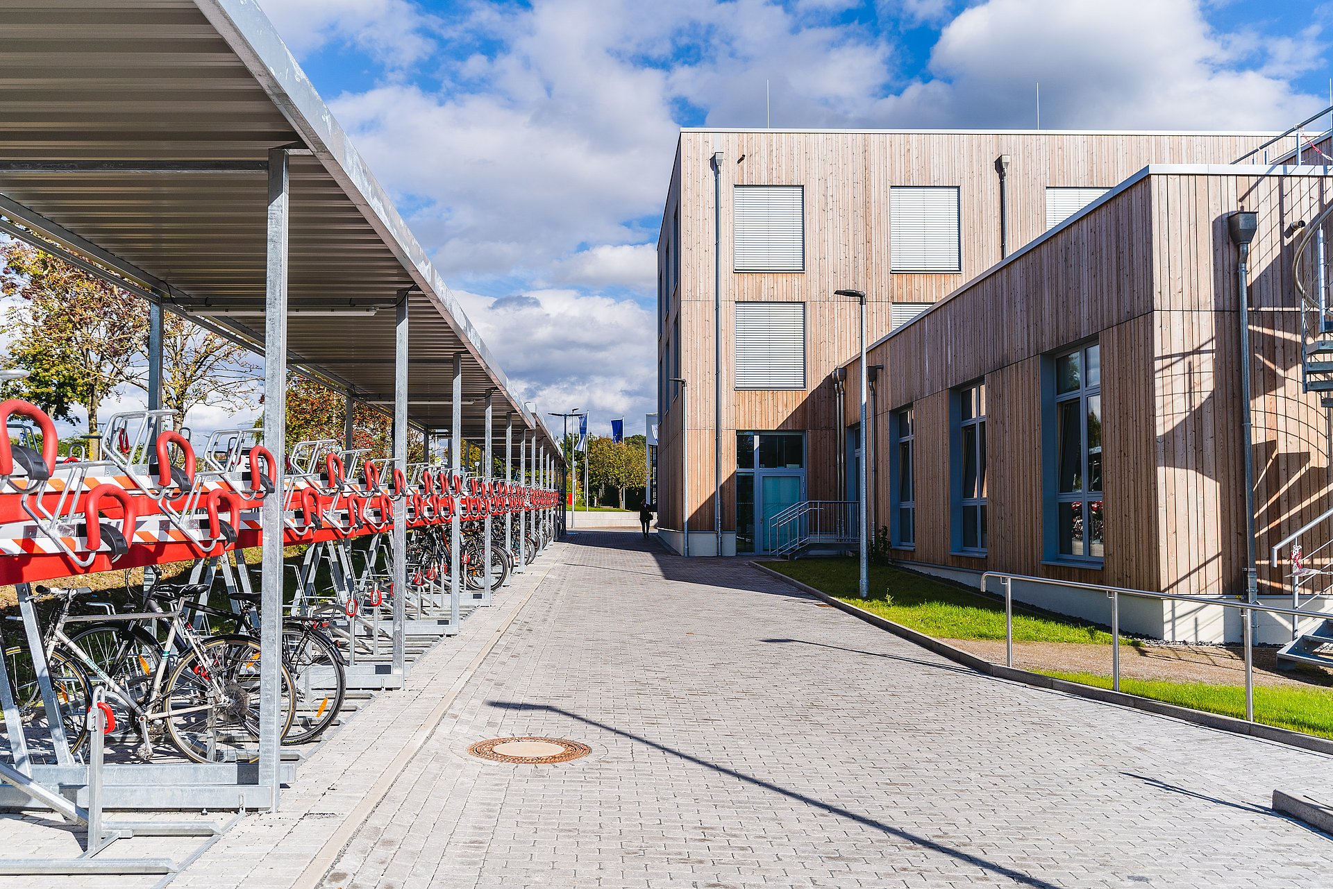 Fahrradständer stehen vor dem Holzgebäude der UW/H