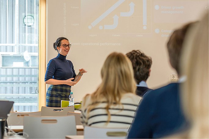 Foto von einer Referentin, die zu Seminartelnehmenden spricht.