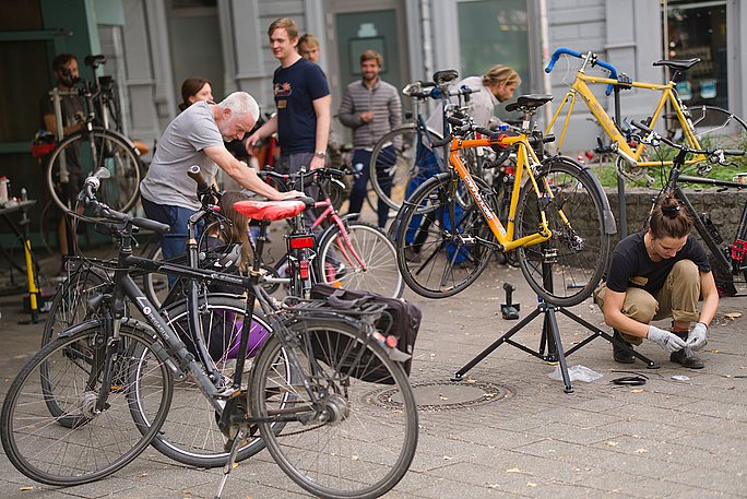 Menschen reparieren ihre Fahrräder