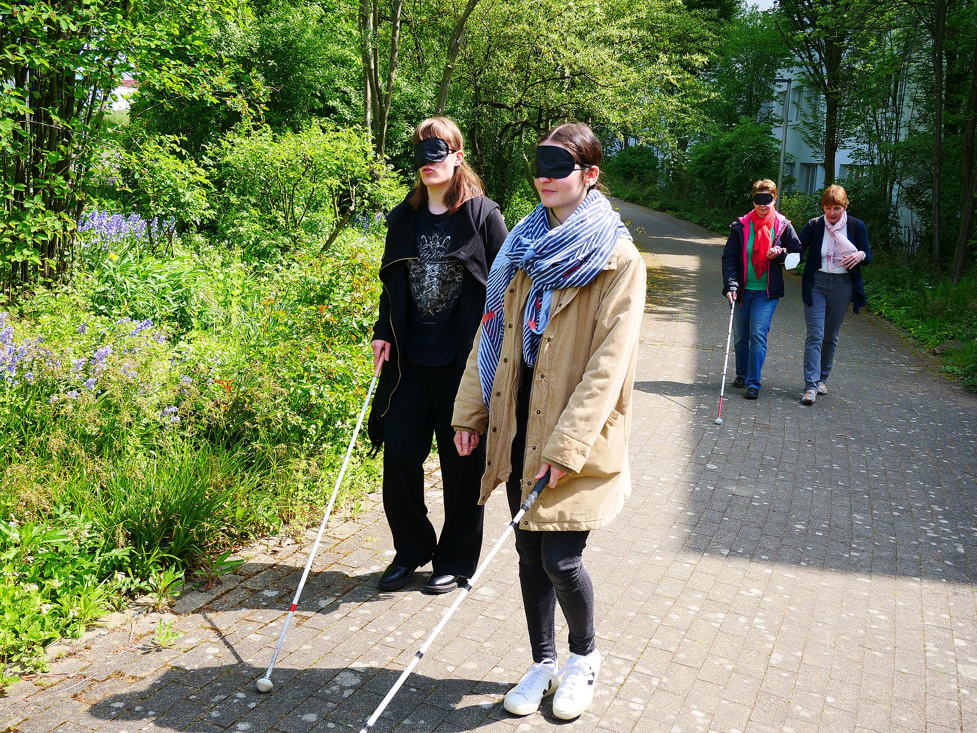 Ausgestattet mit Dunkelbrille und Blindenstock lassen sich Universitätsangehörige über den Campus führen. Ihnen wird so der Alltag eines blinden Menschen ein Stück nähergebracht.