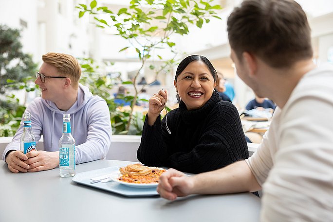 Studierende sitzen in der Mittagszeit in der Cafeteria der UW/H.