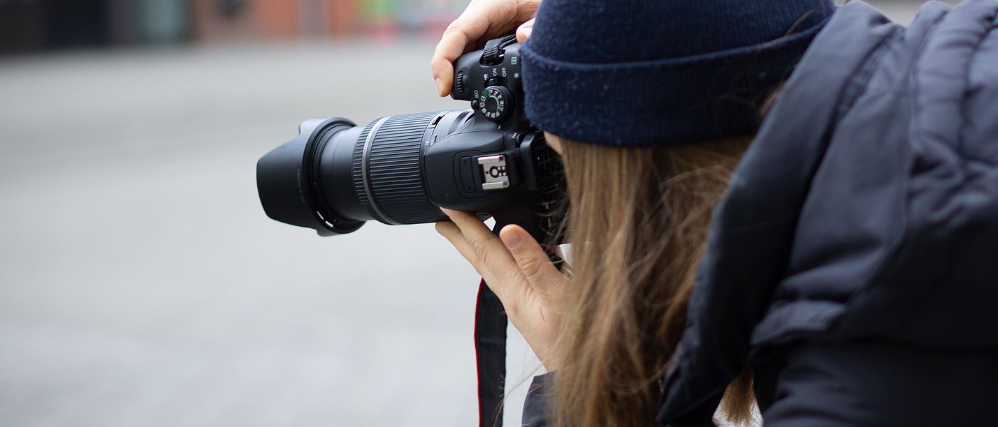 A woman takes pictures with a camera.