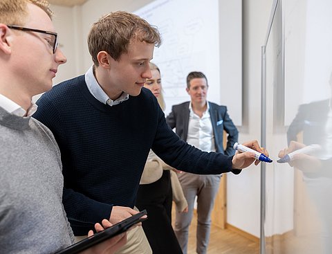 Studierende und ein Professor in einem interaktiven Seminar im Bereich Wirtschaft & Gesellschaft