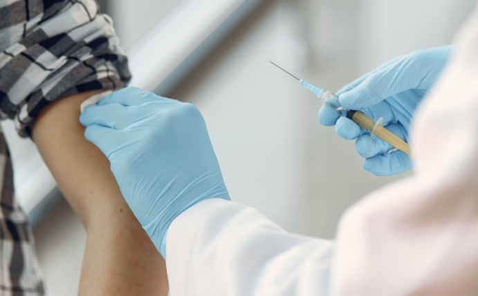 A person receives a vaccination in the upper arm.