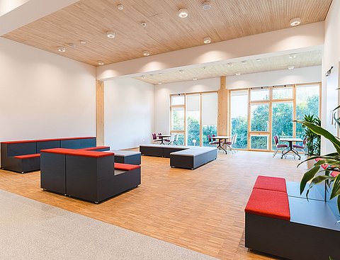 Foyer with a large window front, seating and plants