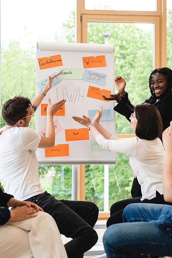 Studierende mit Flipchart beschreiben den Vibe an der UW/H.