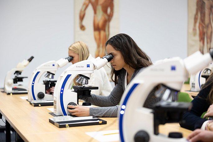 Three people at the microscope