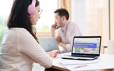 Eine Studentin sitzt vor einem Laptop.