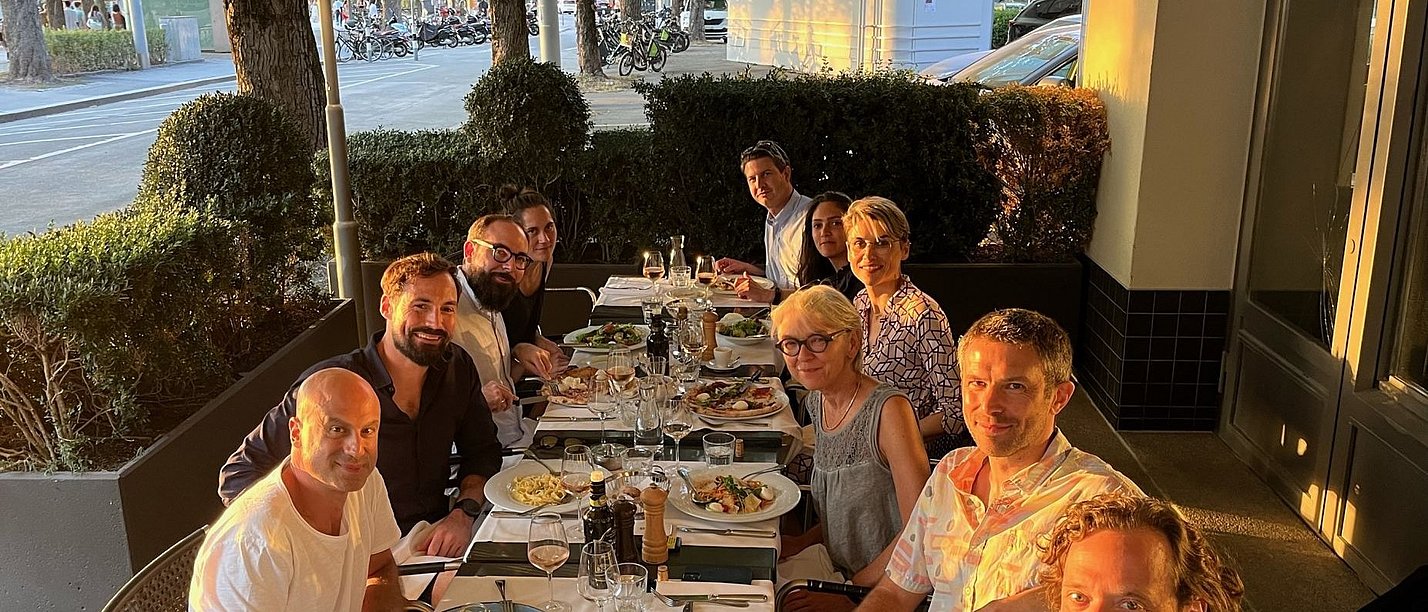 A group of people are sitting on a restaurant terrace.