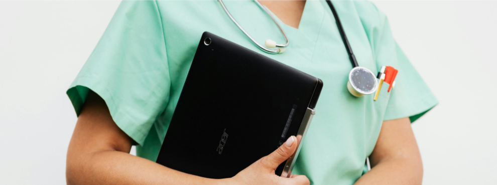 A woman in green nursing clothing wears a stethoscope around her neck and holds a file.