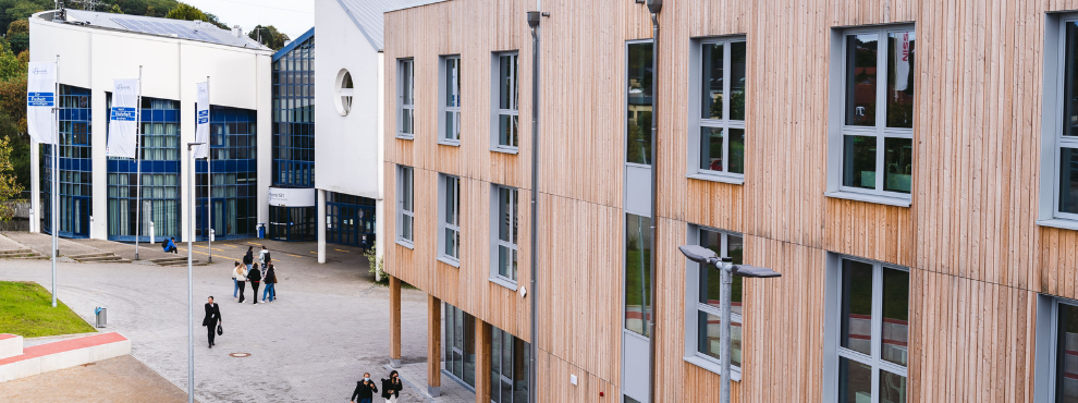 Zwei Gebäude der UW/H. Im Vordergrund der Neubau, im Hintergrund das Hauptgebäude.