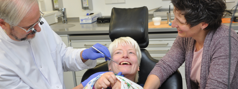 A woman with a disability is treated by a dentist.