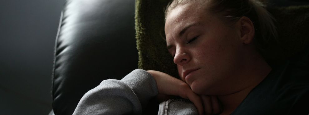 Close-up of a woman sleeping in an armchair.