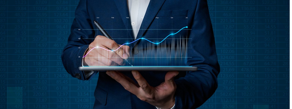 A man in a suit stands in front of a dark blue background and holds up an animated graphic that stands for growth.