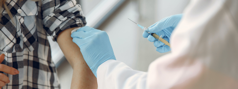 A person receives a vaccination in the upper arm.